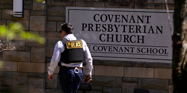 A police officer walks through the entrance of Covenant School after a shooting in Nashville, Tennessee.