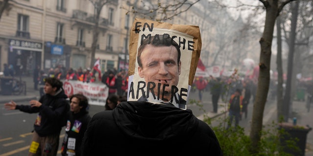 Demonstrant ima iznad glave poster koji ismijava francuskog predsjednika Emmanuela Macrona tijekom prosvjeda 28. ožujka 2023. u Parizu.