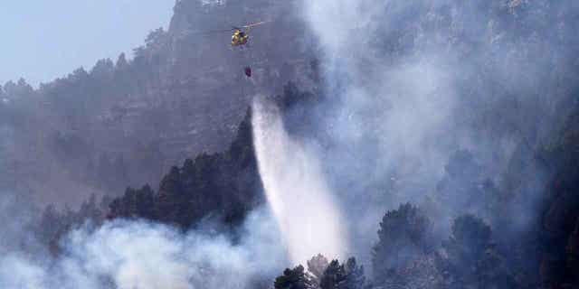 Un helicóptero arroja agua sobre un incendio forestal en Montanejos, Castellón de la Plana, España, el 26 de marzo de 2023.