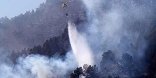 Un helicóptero arroja agua sobre un incendio forestal en Montanejos, Castellón de la Plana, España, el 26 de marzo de 2023.