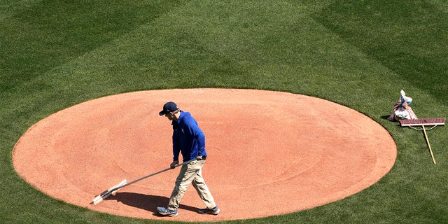 A member of the Kansas City Royals outfield team works on the field in preparation for the 2023 baseball season on Wednesday, March 29, 2023, at Kauffman Stadium in Kansas City, Missouri.  The Royals will host the Minnesota Twins on MLB Opening Day tomorrow.