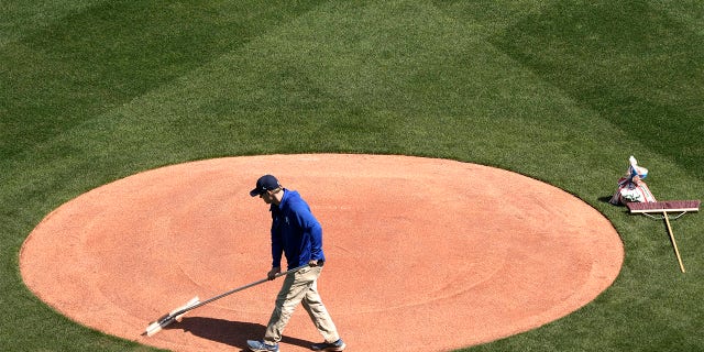 A member of the Kansas City Royals outfield team works on the field in preparation for the 2023 baseball season on Wednesday, March 29, 2023, at Kauffman Stadium in Kansas City, Missouri.  The Royals will host the Minnesota Twins on MLB Opening Day tomorrow.