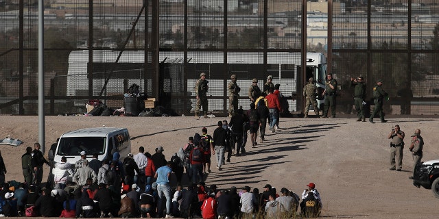 Migrants walk into U.S. custody after crossing the border from Ciudad Juarez, Mexico, on March 29, 2023. A day earlier, dozens of migrants died in a fire at a migrant detention center in Ciudad Juarez.