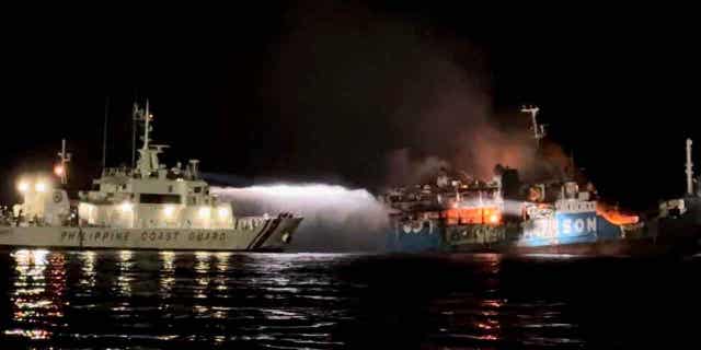 A Philippine Coast Guard ship tries to extinguish a fire on the MV Lady Mary Joy at Basilan, Philippines, on early March 30, 2023. At least 31 people died in the fire.