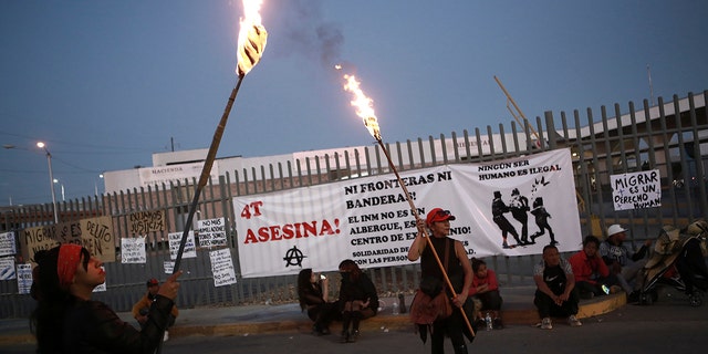 Activists protest outside a migrant detention center in Ciudad Juarez, Mexico, March 29, 2023, a day after dozens of migrants died in a fire at the center. 