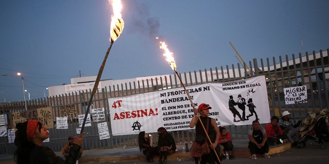 Activists protest outside a migrant detention center in Ciudad Juarez, Mexico, March 29, 2023, a day after dozens of migrants died in a fire at the center.