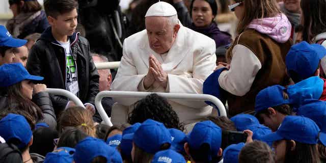 Pope Francis meets children in St. Peters Square, at the Vatican, on March 29, 2023. Francis is being discharged from the hospital where he's being treated for bronchitis.