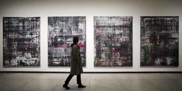 A woman walks in front of the Birkenau paintings in a new exhibition of art works created by Gerhard Richter at the Neue Nationalgalerie museum in Berlin, Germany, on March 31, 2023.