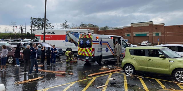 Emergency personnel check on people in a parking lot after a severe storm in Little Rock, Ark., Friday, March 31, 2023.