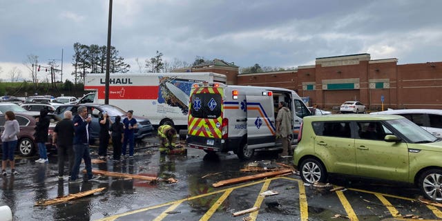 Emergency personnel check people in a parking lot after severe storm swept through Little Rock, Ark., Friday, March 31, 2023.