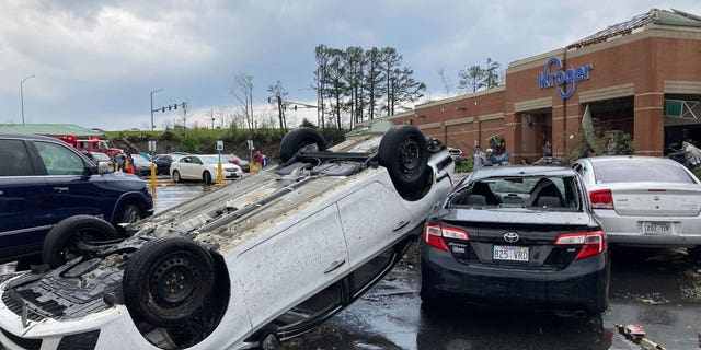 A car is upturned in a Kroger parking lot after a severe storm swept through Little Rock, Ark., Friday, March 31, 2023. (AP Photo/Andrew DeMillo)