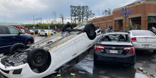 A car is upturned in a Kroger parking lot after a severe storm swept through Little Rock, Ark., Friday, March 31, 2023. (AP Photo/Andrew DeMillo)