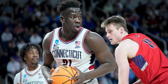 Connecticut's Adama Sanogo (21) looks to pass after rebounding against St. Mary's Mitchell Saxen (11) in the first half of a second-round college basketball game in the NCAA Tournament, Sunday, March 19, 2023, in Albany, N.Y. 