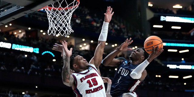 Joe Munden Jr. , #1 of the Fairleigh Dickinson Knights, kicks the ball against Alijah Martin, #15 of the Florida Atlantic Owls, during the second half of a second round game of the NCAA Men's Basketball Tournament at Nationwide Arena on March 19, 2023 in Columbus, Ohio.