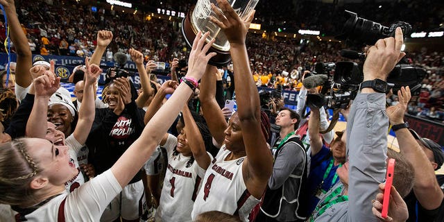 Aliyah Boston of South Carolina holds up the championship trophy after defeating Tennessee 74-58 to win the championship game of the Southeastern Conference Tournament in Greenville, SC on March 5, 2023.