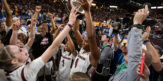 Aliya Boston of South Carolina holds the championship trophy after defeating Tennessee 74-58 to win the Southeastern Conference championship game in Greenville, South Carolina on March 5, 2023.