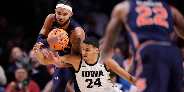 Johni Broome #4 of the Auburn Tigers and Kris Murray #24 of the Iowa Hawkeyes battle for the ball during the second half of the first round of the NCAA Men's Basketball Tournament at Legacy Arena at BJCC on March 16, 2023 in Birmingham, Alabama.