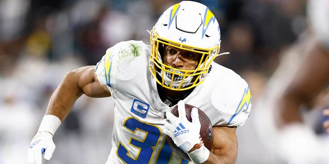 Austin Ekeler, #30 of the Los Angeles Chargers, carries the ball against the Jacksonville Jaguars during the first half of the game in the AFC Wild Card playoff game at TIAA Bank Field on Jan. 14, 2023 in Jacksonville, Florida.
