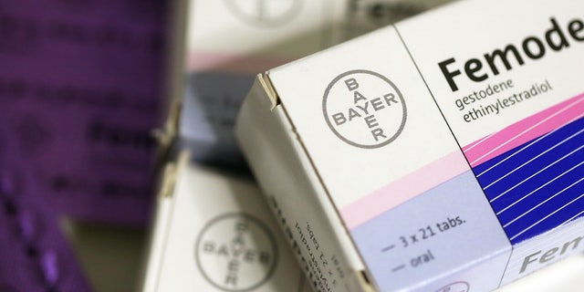 Blister packs containing Femoden oral contraceptive tablets, produced by Bayer AG, sit on a pharmacy counter.