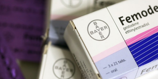 Blister packs containing Femoden oral contraceptive tablets, produced by Bayer AG, sit on a pharmacy counter.