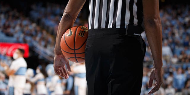 A referee holds a ball during a game between the North Carolina Tar Heels and the Elon Phoenix at Dean E. Smith Center on Dec. 11, 2021, in Chapel Hill, North Carolina.