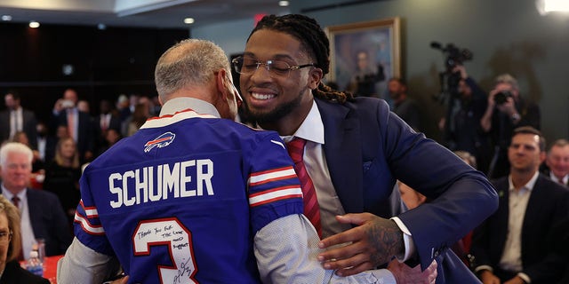 Senate Majority Leader Charles Schumer, left, greets Buffalo Bills safety Damar Hamlin at an event to introduce the Epilepsy Access Act on March 29, 2023 in Washington, D.C.