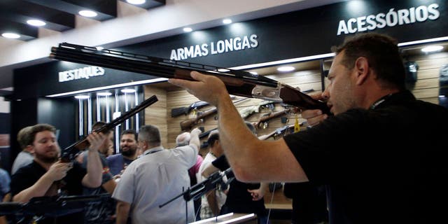 A visitor holds a gun during the Shot Fair Brasil, an arms exhibition held at the Expoville Conventions and Exhibitions Centre in Joinville, Santa Catarina State, Brazil, on August 5, 2022.