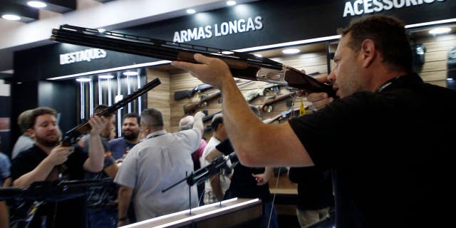 A visitor holds a gun during the Shot Fair Brasil, an arms exhibition held at the Expoville Conventions and Exhibitions Centre in Joinville, Santa Catarina State, Brazil, on August 5, 2022.