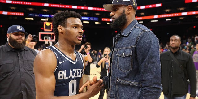 Bronny James, #0 of the Sierra Canyon Trailblazers, is greeted by his father and NBA player LeBron James after defeating the Perry Pumas in the Hoophall West tournament at the Footprint Center on December 11, 2021 in Phoenix.