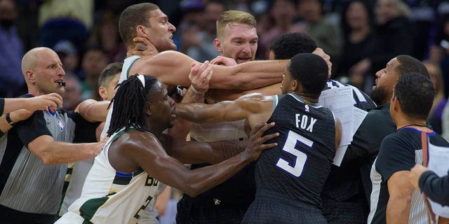 Milwaukee Bucks center Brook Lopez, left scuffles with Sacramento Kings forward Trey Lyles as members of both teams intervene in the final seconds of the second half of an NBA basketball game in Sacramento, California, Monday, March 13, 2023.