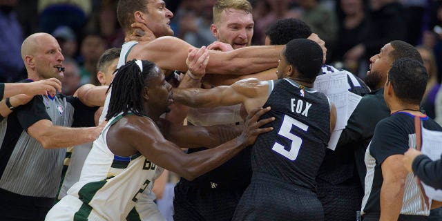 Milwaukee Bucks center Brook Lopez, left scuffles with Sacramento Kings forward Trey Lyles as members of both teams intervene in the final seconds of the second half of an NBA basketball game in Sacramento, California, Monday, March 13, 2023.