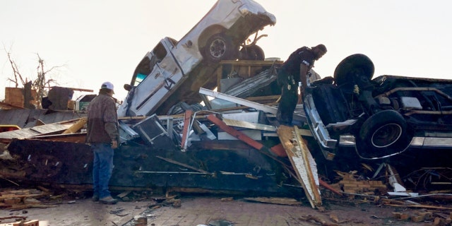 Law-enforcement officers climb through debris on a diner looking for survivors early Saturday, March 25, 2023, in Rolling Fork, Miss.  No one was found. Emergency officials in Mississippi say several people have been killed by tornadoes that tore through the state on Friday night, destroying buildings and knocking out power as severe weather produced hail the size of golf balls moved through several southern states.