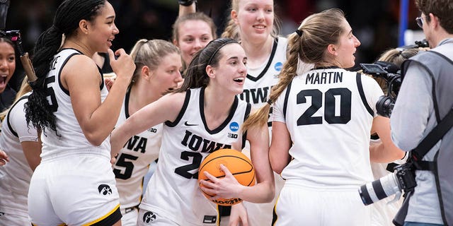 Iowa players, including guard Caitlin Clark, front center, forward Hannah Stuelke, front left, and guard Kate Martin, #20, celebrate after an Elite 8 basketball game of the NCAA Tournament against Louisville, Sunday, March 26, 2023, in Seattle.