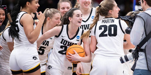 Iowa players, including guard Caitlin Clark, front center, forward Hannah Stuelke, front left, and guard Kate Martin, #20, celebrate after an Elite 8 basketball game of the NCAA Tournament against Louisville, Sunday, March 26, 2023, in Seattle.