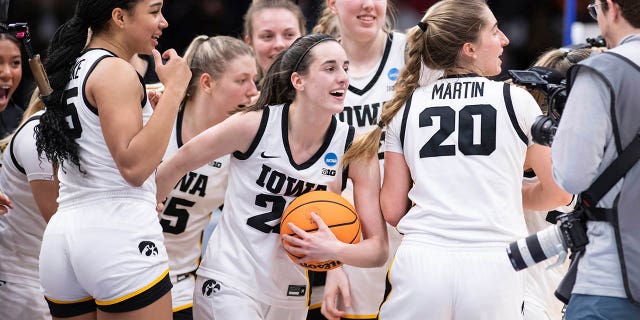 Iowa players, including guard Caitlin Clark, center front, forward Hannah Stuelke, left front, and guard Kate Martin, #20, celebrate after an NCAA Tournament Elite 8 basketball game against Louisville on Sunday March 26, 2023, in Seattle.