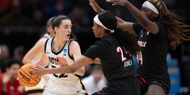 Iowa guard Caitlin Clark, left, looks to pass the ball against Louisville guard Morgan Jones, center, and forward Olivia Cochran during the first half of an Elite 8 college basketball game of the NCAA Tournament, Sunday, March 26, 2023, in Seattle.