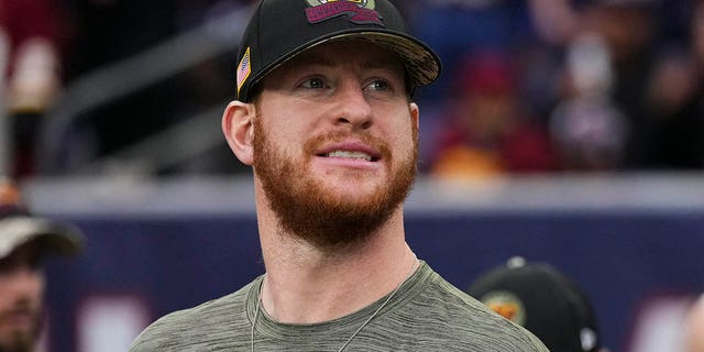 Carson Wentz of the Washington Commanders stands for the national anthem before the Texans game at NRG Stadium on November 20, 2022 in Houston.