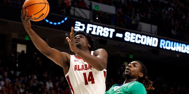 Alabama center Charles Bediako (14) lays in a basket as Texas A&M Corpus Christi forward De'Lazarus Keys (13) defends in the first half of a first-round college basketball game in the NCAA Tournament in Birmingham, Ala., Thursday, March 16, 2023.