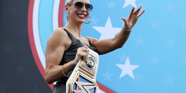 La campeona femenina de Smackdown, Charlotte Flair, camina por el escenario durante las ceremonias previas a la carrera antes de la 65.ª edición anual de la NASCAR Cup Series Daytona 500 en el Daytona International Speedway el 19 de febrero de 2023 en Daytona Beach, Florida.