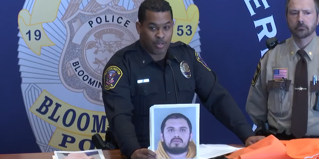Bloomington Police Chief Booker Hodges holds up mug shot of man arrested for allegedly soliciting sex in a prostitution sting.
