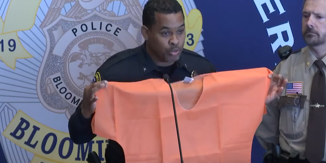 Bloomington Police Chief Booker Hodges holds up an orange jumpsuit after prostitution sting.