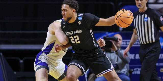 Christian Parker of Mount Union Purple Raiders drives to the basket against Caleb Furr of Christopher Newport Captains during the Division III Men's Basketball Championship on March 18, 2023, in Fort Wayne, Indiana.