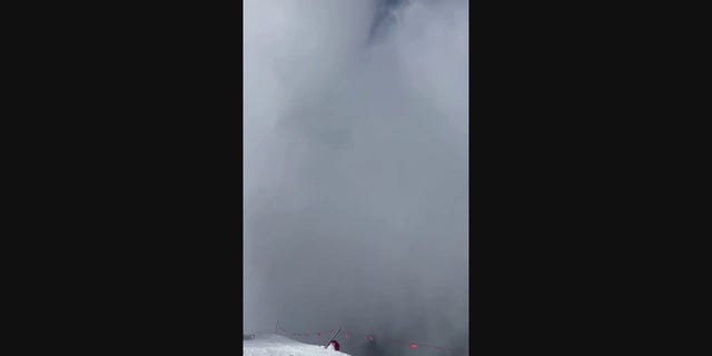 Snow fills the frame of the video as the avalanche hits the ridge