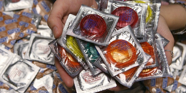 FILE - Katie Freitas, 22, a senior at Stonehill College, shows off condoms that she distributes to other students, Wednesday, March 4, 2009, in Easton, Massachusetts.