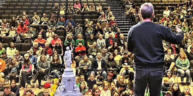 Kirk Cameron stands on stage and addresses the families and children assembled for a kids' book reading event in Fayetteville, Arkansas. About 500 or so people were in attendance, the publisher said. 