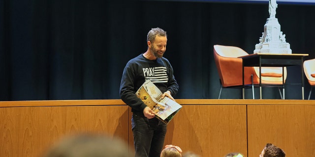 Actor and writer Kirk Cameron reads to the families and children who came out to hear him speak in Fayetteville, Arkansas, on Friday, March 17.