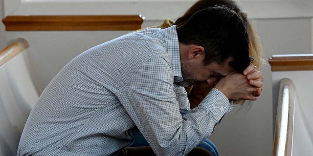 Congregants pray during a vigil at Woodmont Christian Church for victims of the mass shooting at Covenant School