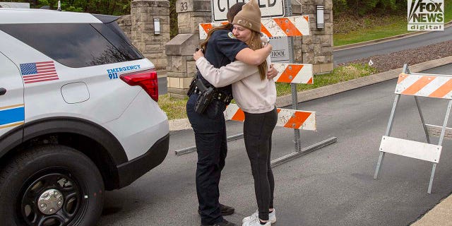 A police officer hugs a mourner outside of the Covenant School in Nashville.