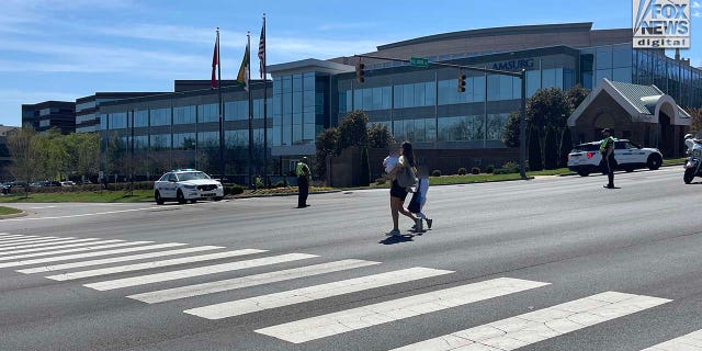 Parents walk out with their children following reports of a shooting at Covenant School in Nashville, Tennessee on Monday, March 27, 2023.