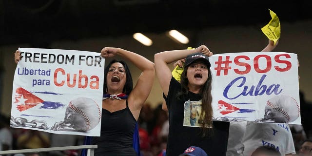 Protesters hold signs and chant during the sixth inning of a World Baseball Classic game between Cuba and the United States, Sunday, March 19, 2023, in Miami.